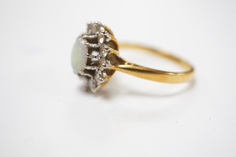 A modern 18ct gold, white opal and diamond set oval cluster ring, size M/N, gross weight 4.6 grams, the opal weighing approximately 0.50ct, total diamond weight approx. 0.48ct. Condition - fair to good